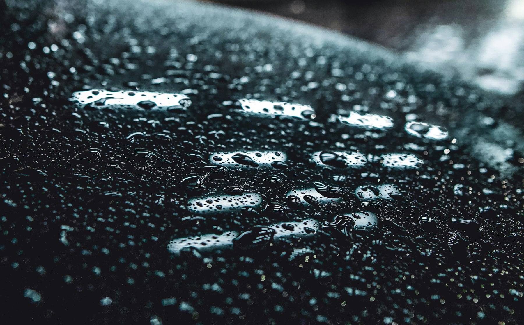 Water droplets beading on a ceramic-coated black surface